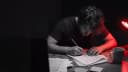 A copywriter marking up a printed draft by hand at a desk