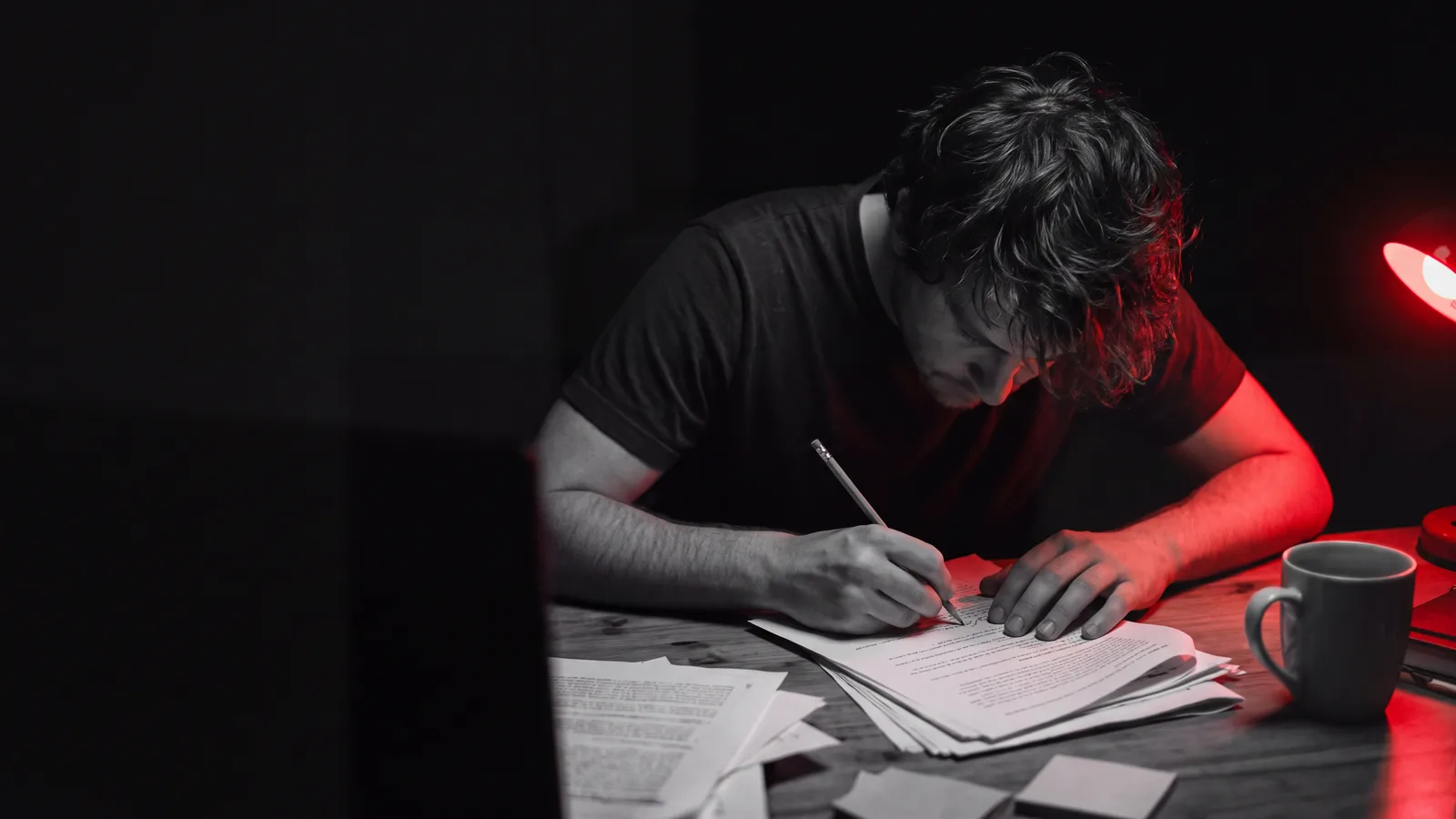 A copywriter marking up a printed draft by hand at a desk